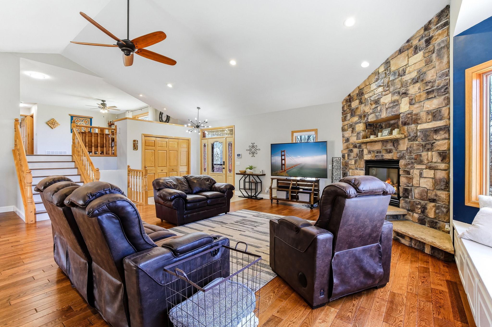 Open Great Room with wood floors, vaulted ceiling, and views toward the entry and upper level.