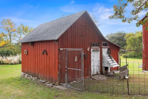 Medium-sized, two-level barn offering versatile use for animals or storage—ideal as a chicken coop above with open shelter below that connects to the fenced lot
