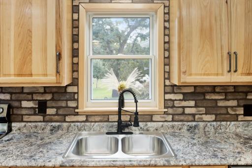 Window above the sink provides a perfect view to keep an eye on kids at play or animals in the yard while enjoying the comforts of the kitchen.