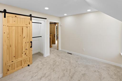 Spacious upstairs bedroom with a large, thoughtfully designed closet complete with lighting.