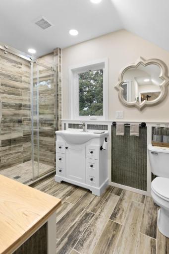 Upstairs full bath featuring a tiled walk-in shower and tin accents that add a modern touch.