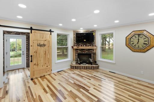 Featuring a fireplace accented with Koni tile and surrounded by rich hickory floors, this inviting living space offering a welcoming and comfortable space to share with loved ones.