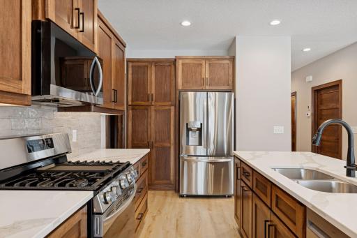 Tile backsplash, under cabinet lighting and stainless steel appliances.