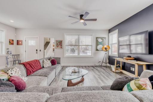 The living room is a beautiful large space, with freshly painted walls and new ceiling fan/light fixture.