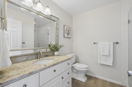 2nd bathroom on the upper level with granite countertop and frameless glass walk in shower