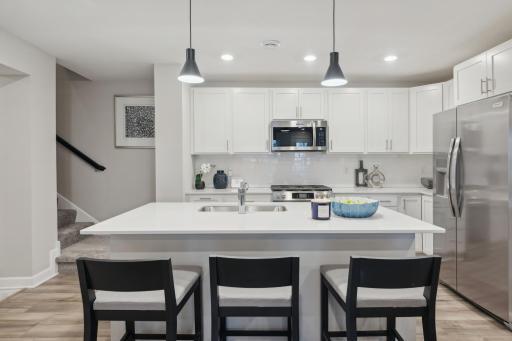 (Photo of decorated model, actual home's finishes vary) Welcome to your new home! This spacious kitchen features a large center island with quartz countertops, under mount sink, recessed lighting, LVP hardwood floors, stainless appliances and more!
