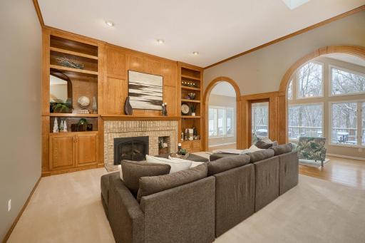Main floor Family Room, a quiet place to retreat and an Amazing place to entertain! Brick Gas-Fireplace, Rich Custom Woodwork, Built-in Cabinetry & Shelving, Arched Doorways to the Sun Room, Custom Wetbar/Coffee Station, and sunlight!