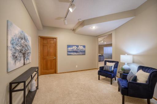 Lower-Level Flex room, perfect for a Library, or Game Table space. Door opens to Large Storage & Utility Area.