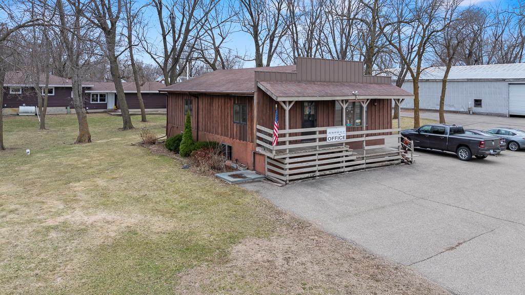 A welcoming main office with an open framed porch with asphalt parking space