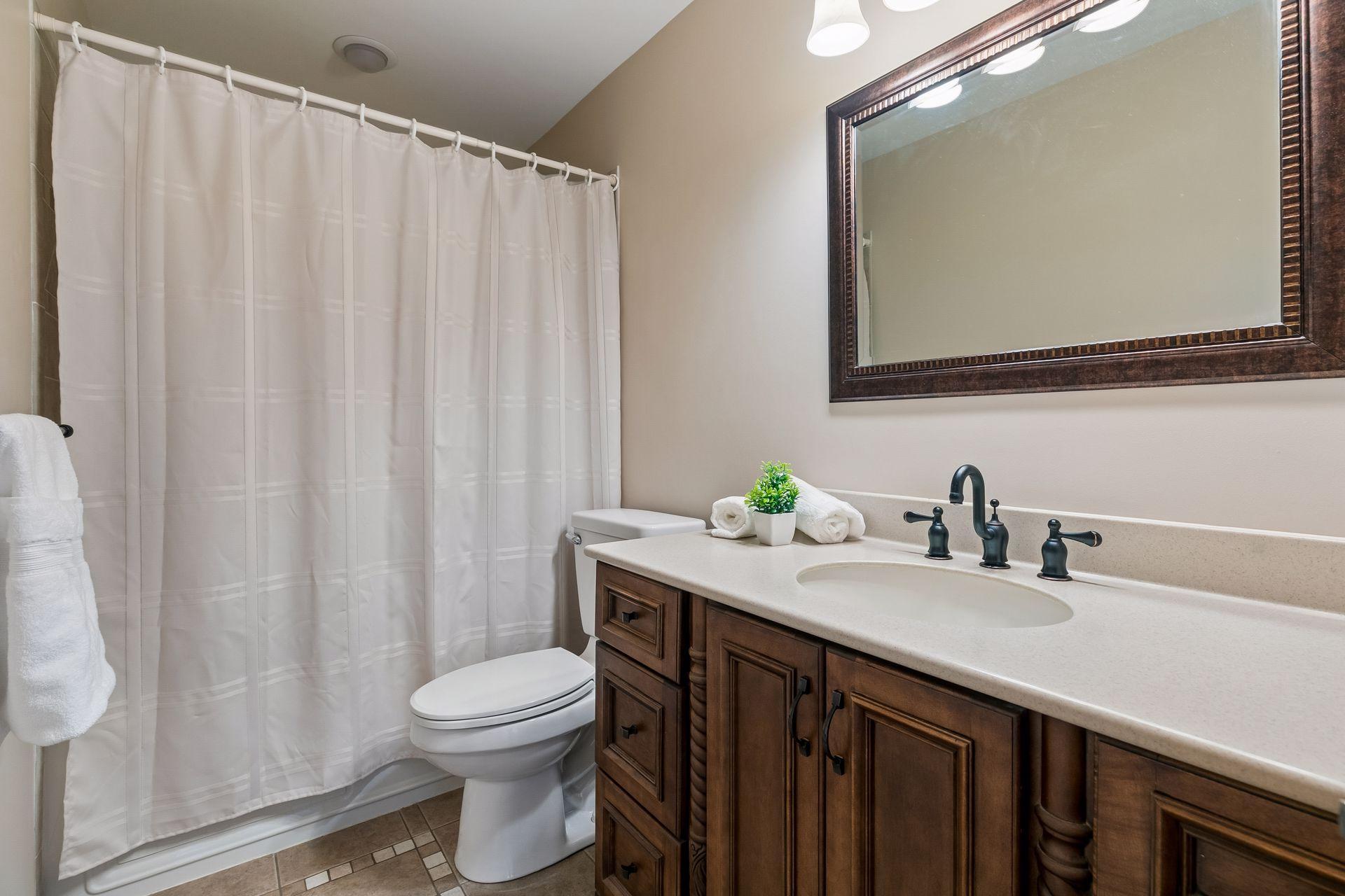 Upper-level full bathroom with oversized vanity, updated fixtures, neutral finishes and convenient layout serving additional upper-level bedrooms.