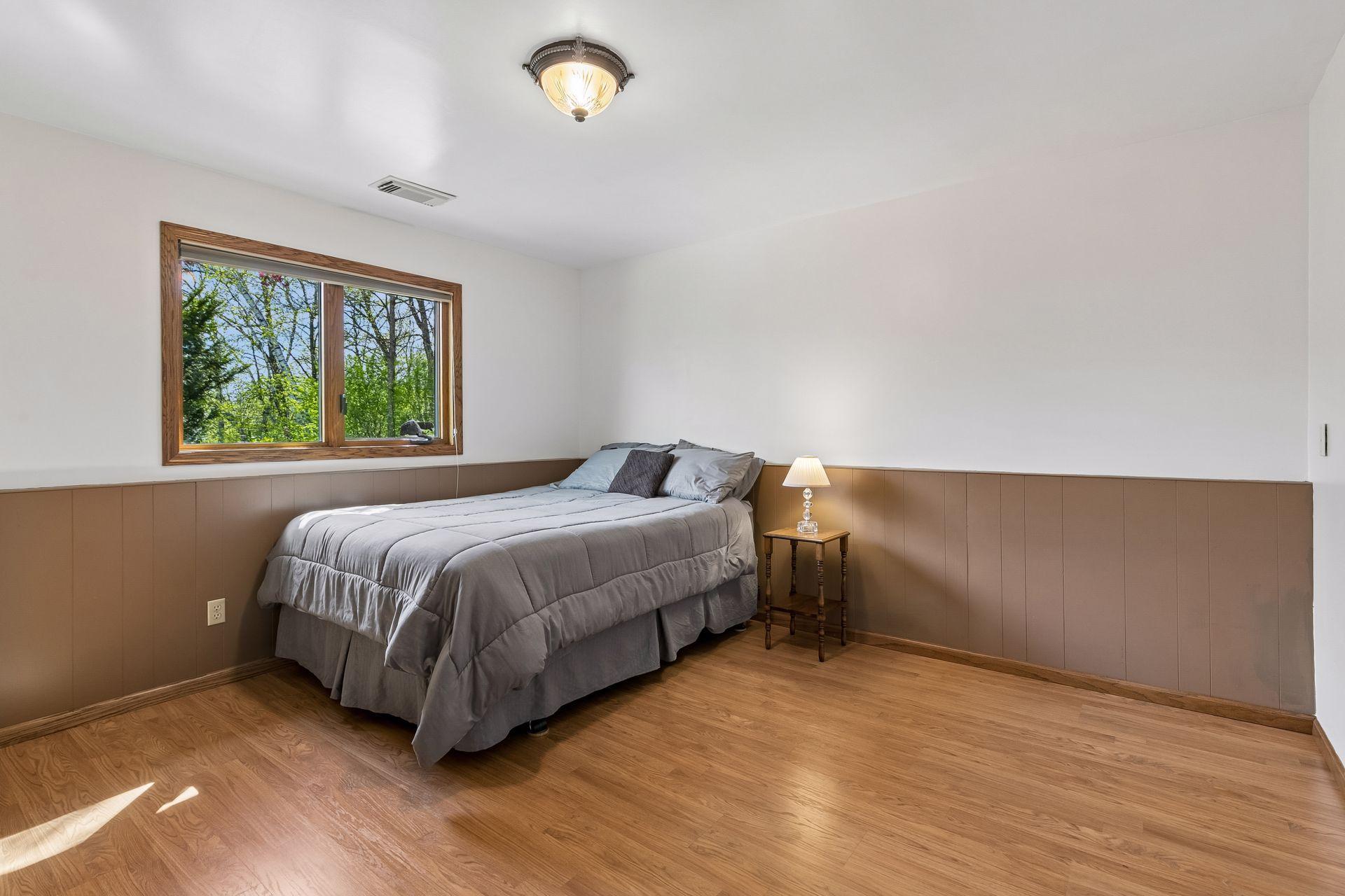 Lower-level 4th bedroom with large window, natural light and flexible layout ideal for guests, multigenerational living, home office or workout room.