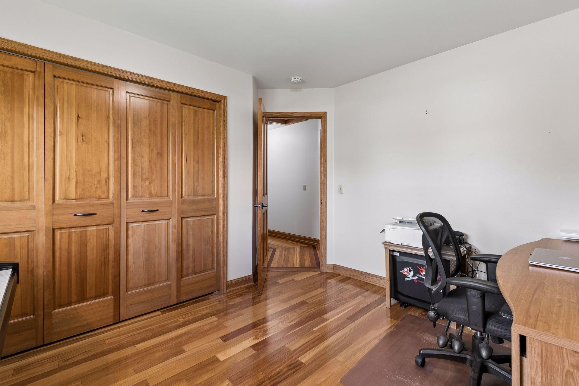 Upper-level third bedroom with rich natural wood trim, large closet and flexible space for bedroom setup, nursery, study area or home office.