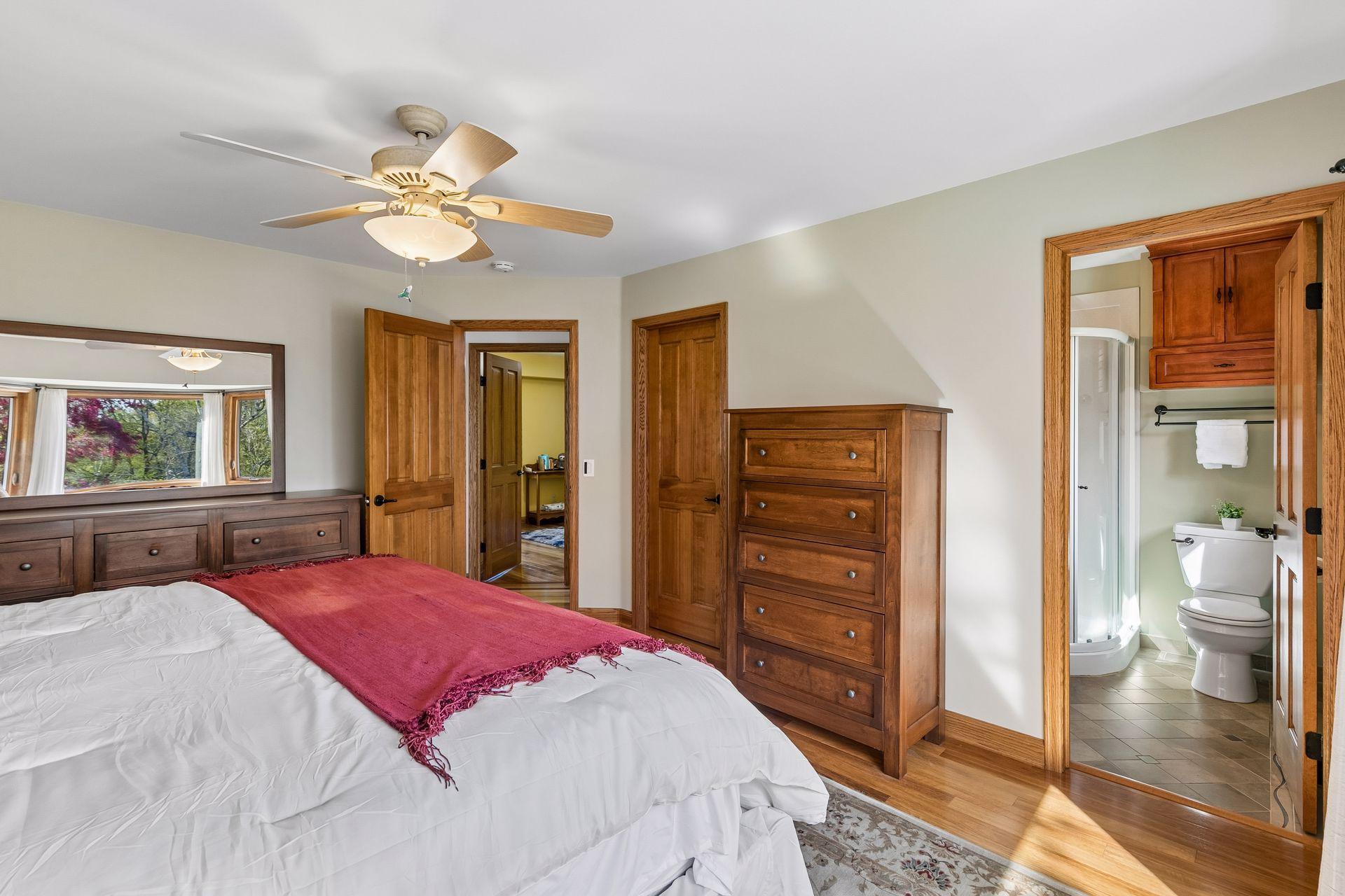 Spacious owner’s suite with private 3/4 bathroom, walk-in closet, natural wood trim and doors, and beautiful backyard views offering comfort, privacy and functionality.