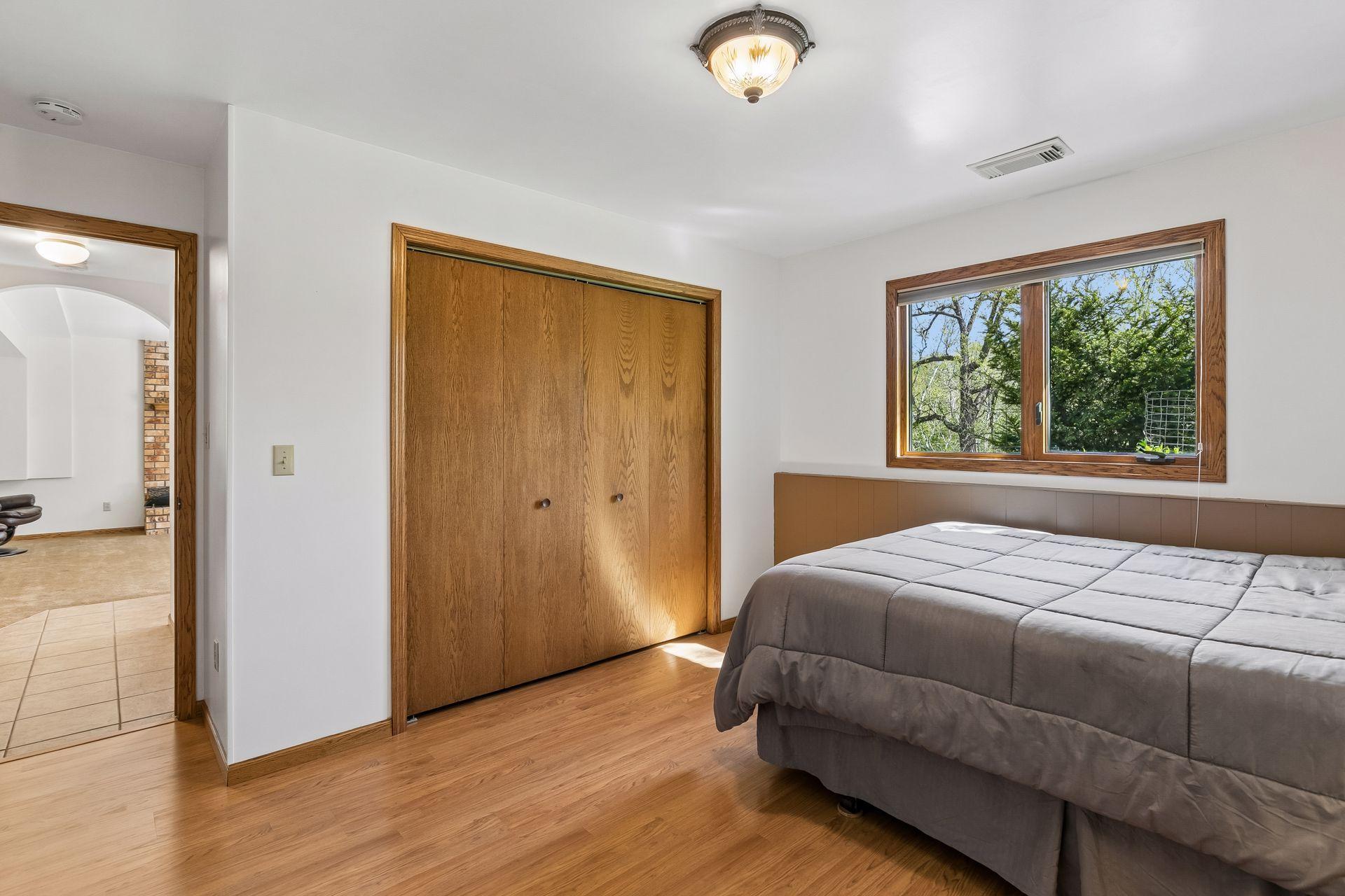 Additional view of the lower-level 4th bedroom showcasing generous closet space, neutral finishes and comfortable layout with easy access to the lower-level bathroom.