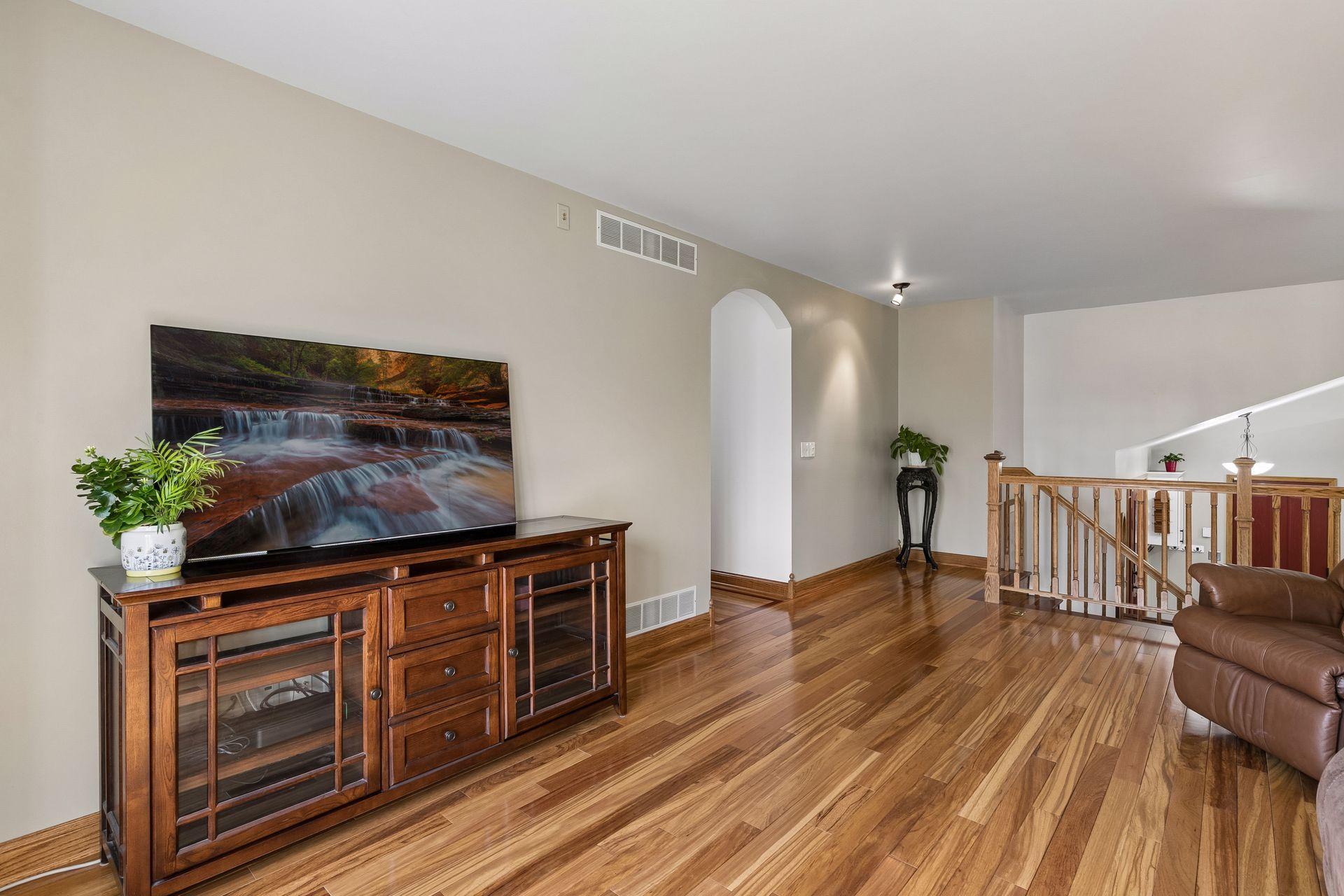 Stunning upper-level family living space with vaulted ceilings, rich natural woodwork, and open flow connecting the living room, dining room and kitchen.