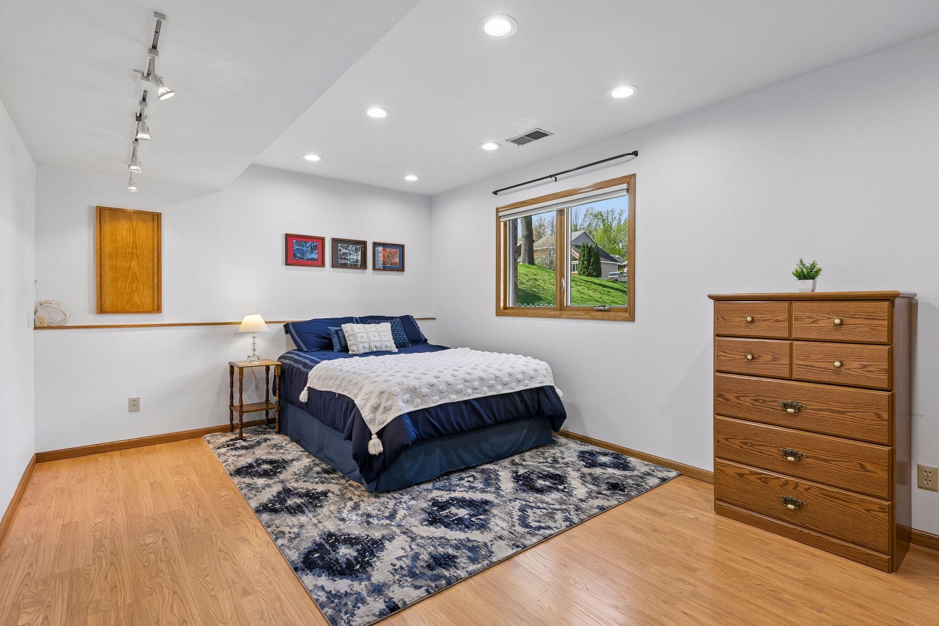 Spacious 5th bedroom on the lower level with recessed lighting, large window and flexible space perfect for guest suite, teenager room, hobby room, or private home office.