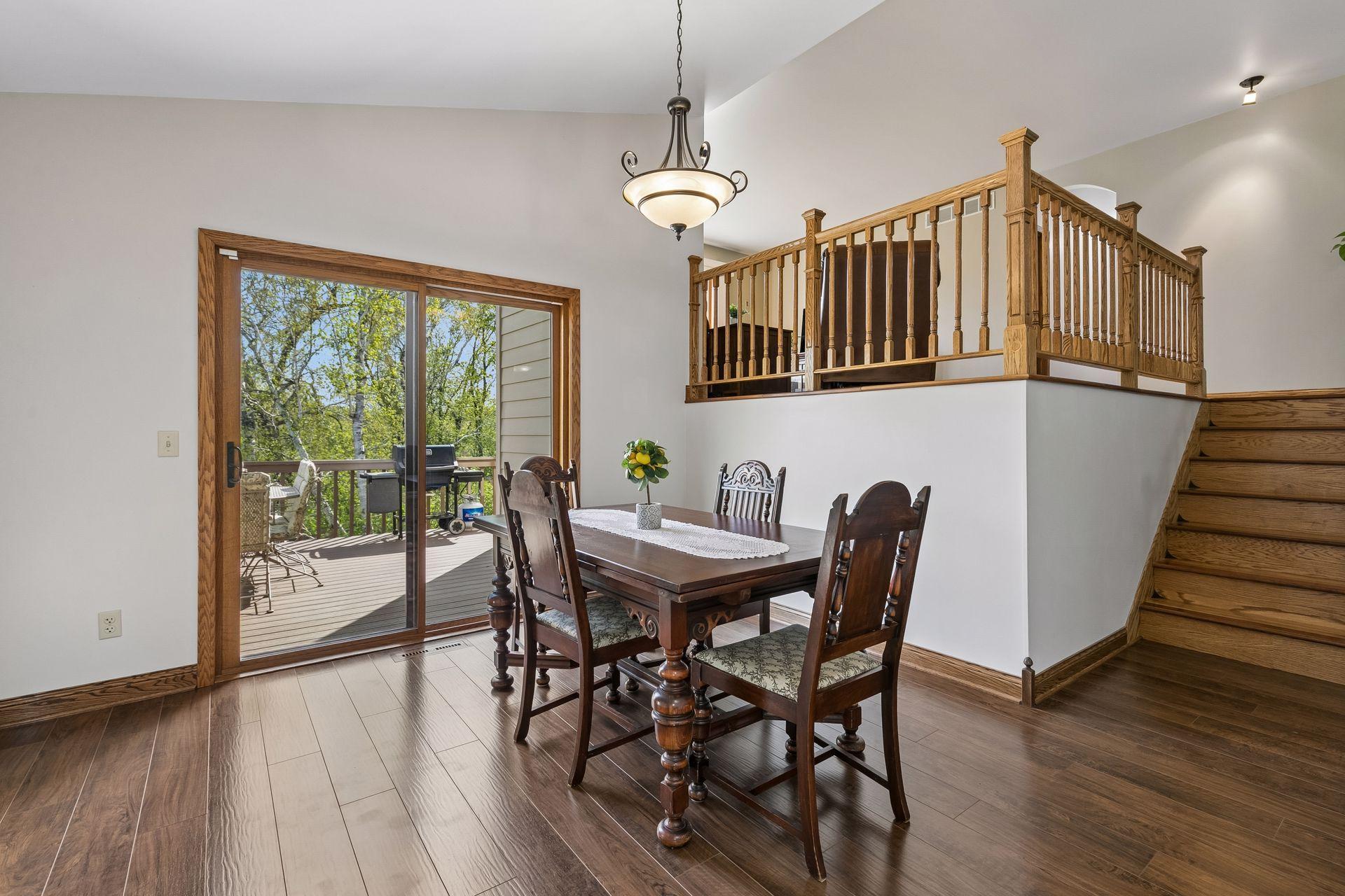 Spacious dining room with large sliding glass door leading to the backyard deck, offering seamless indoor-outdoor living and relaxing wooded views.