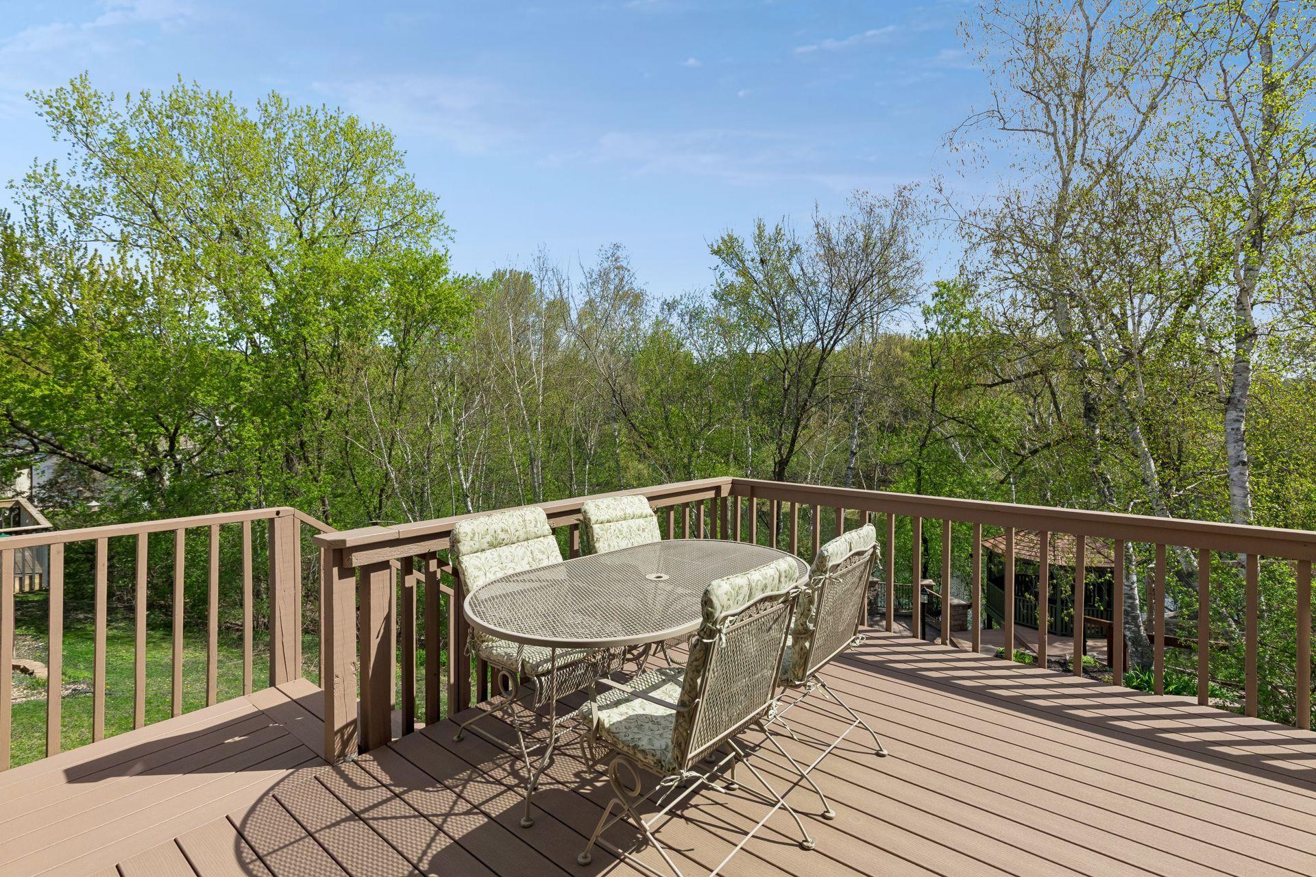 Large maintenance-friendly deck overlooking the private backyard with mature trees and peaceful nature views - a perfect outdoor space for entertaining, grilling or family time.