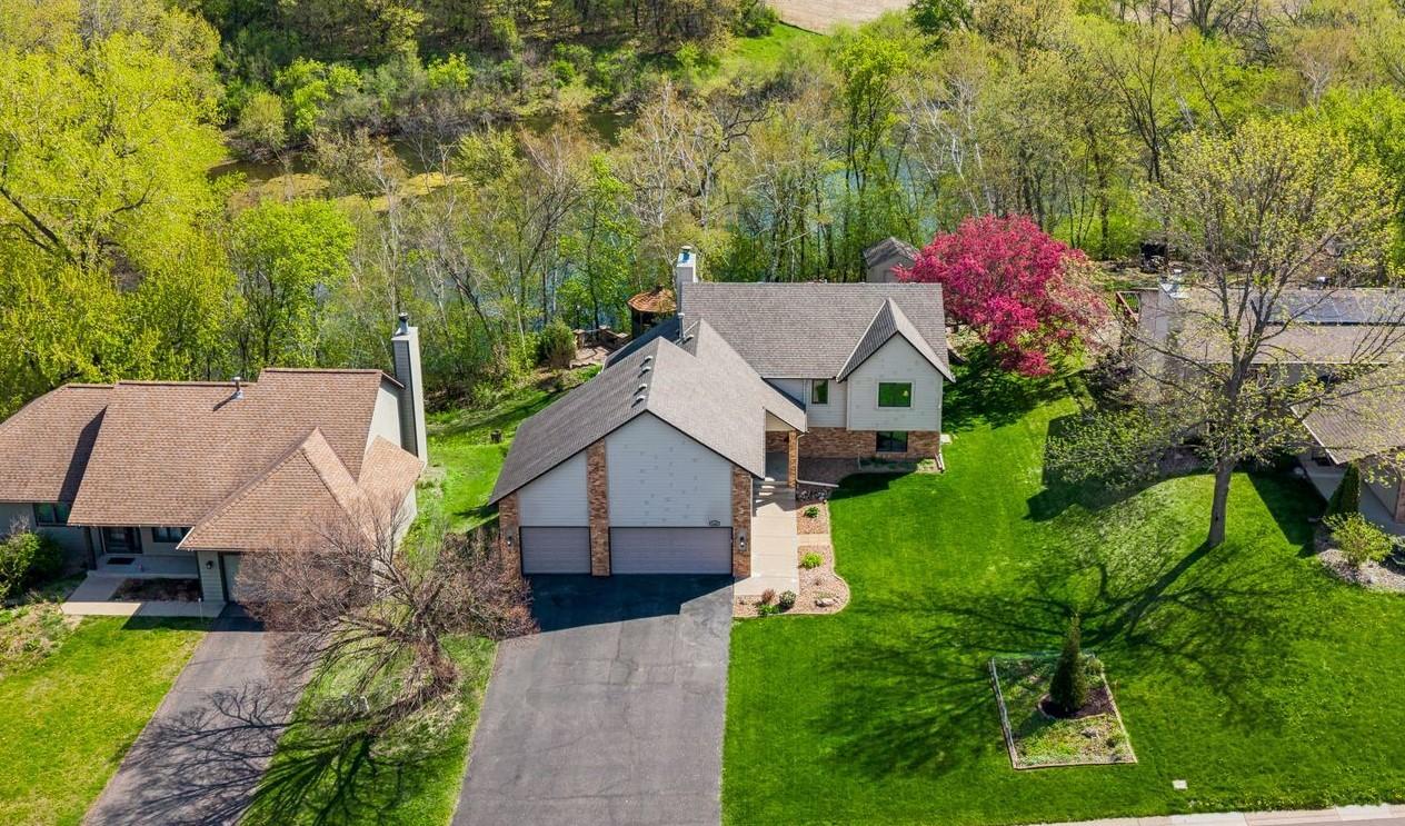 Beautifully maintained 4-level split home in Eagan with 5 bedrooms, 3 bathrooms, and an insulated 3-car garage, located on a private wooded lot with stunning backyard views and mature trees.