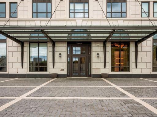 Elegant exterior entry with covered glass canopy.