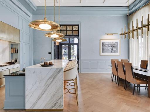 Chef’s kitchen with marble counters, high-end appliances, and seating at the island.