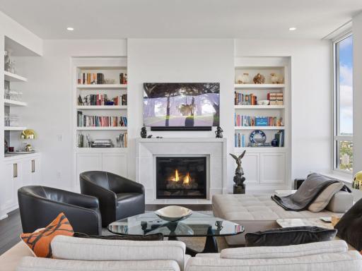 Cozy fireplace focal point with built-in shelving and natural light.