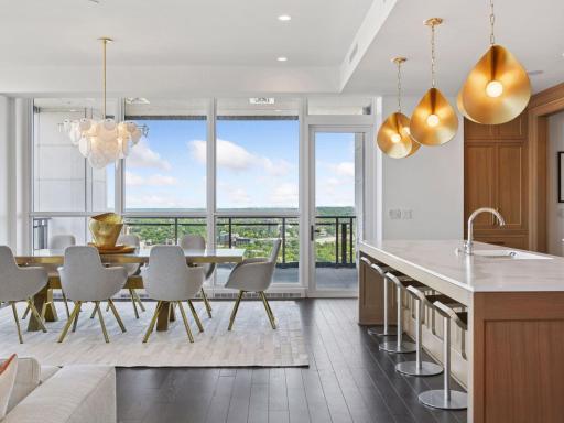 Dining area with floor-to-ceiling windows and access to private balcony.