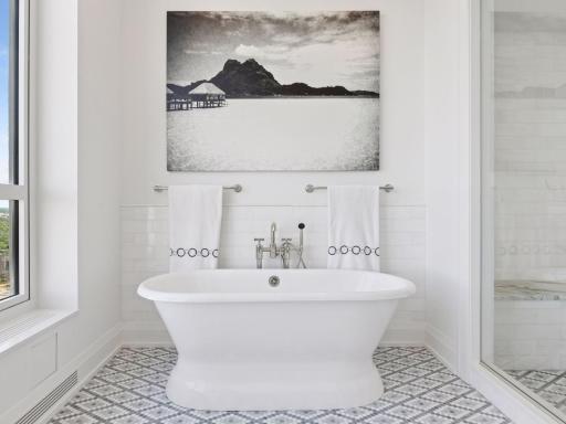 Freestanding soaking tub with city backdrop.