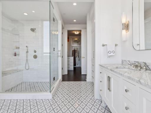 Walk-in glass shower with bench seating.