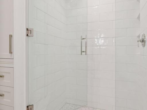 Crisp white tile and hexagon marble flooring.