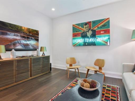 Stylish media space with vibrant art and cozy seating.