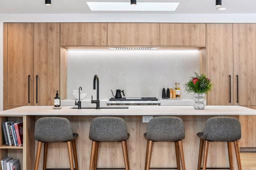Chef's dream kitchen with custom white oak cabinetry and premium quartz waterfall island with seating for six.