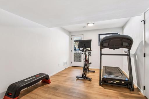 Dedicated home gym with direct walkout access to backyard oasis.