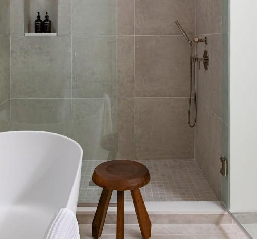 Frameless glass shower with designer tile and rainfall showerhead gives you a luxury spa experience.