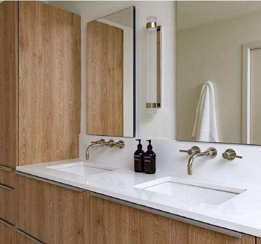 His-and-hers primary bath with dual vanities and brushed fixtures offers plenty of storage.