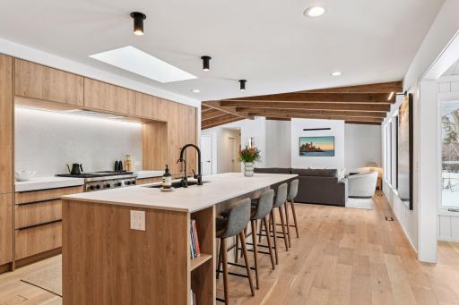This chef's dream kitchen bathes in natural light from expansive windows that frame serene wooded views.