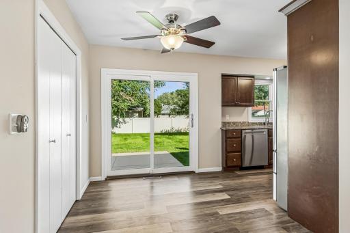 Dining area features ceiling fan, large pantry closet, LVP flooring, and patio door leading to backyard!