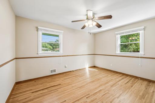 Three bedrooms on one level offering updated vinyl windows, gleaming hardwood floors, and ceiling fan and with light!