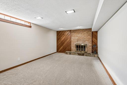 Family room offers handsome and cozy brick wood burning fireplace, new carpet and pad (2026), fresh paint 2026), and recessed lighting!