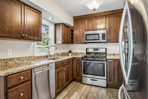 Stainless steel appliances, LVP flooring, and window overlooking fenced-in backyard!