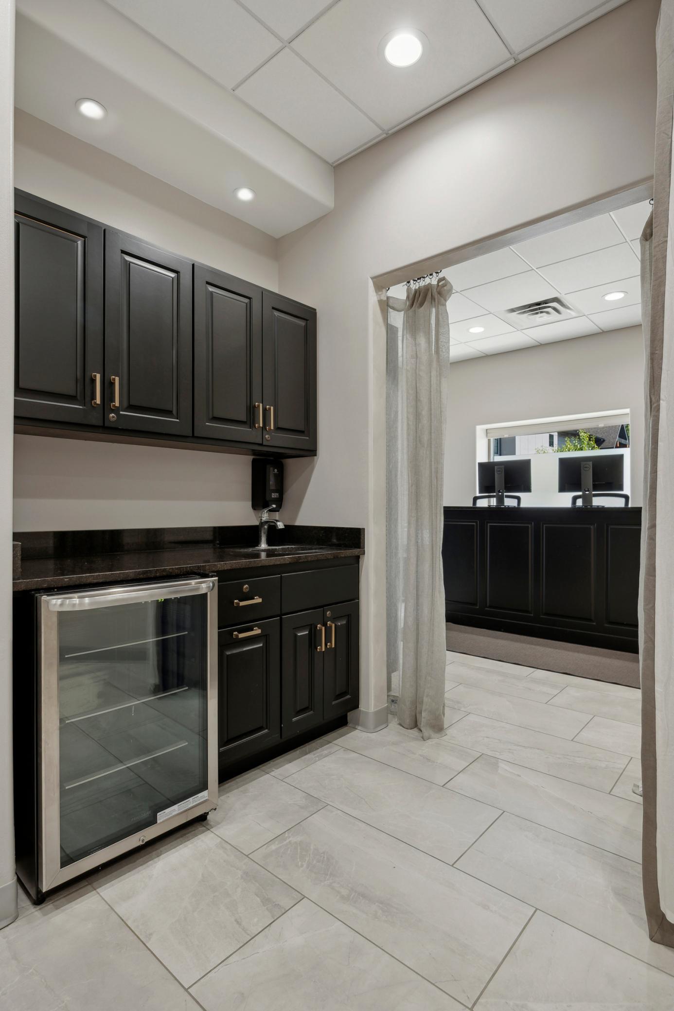 Sleek full kitchenette with refrigerator and coffee station.
