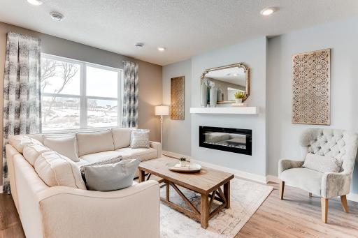 Soaring windows shed light on a main level living space that is large enough to handle most furniture set-ups and features a contemporary electric fireplace and mantle combination! (Photos of the same floorplan, colors are similar)