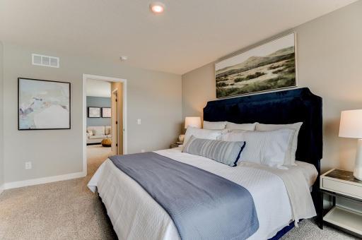 A second view of the Primary Suite, seen here with a King sized bed and very spacious. (Photo of same plan, colors are similar)