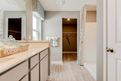 Connected to the primary suite is this bathroom, which includes a double-vanity, stand-in shower and serves as the passage way to the bedrooms oversized walk-in closet!! (Photos of the same floorplan, colors may vary).