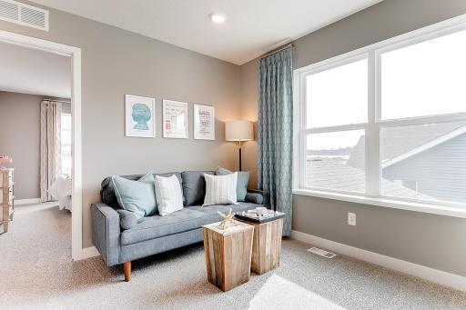 The primary suite is off the back of the home. This space (the home's loft) resides just atop the stairs and offers that second living space families of all sizes have come to appreciate! (Photos of the same floorplan, colors are similar)