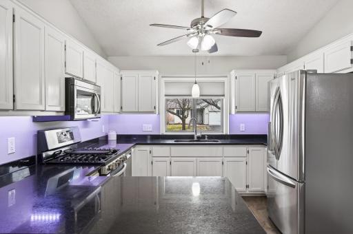 Granite countertop, freshly refinished white cabinets and stainless steel appliances