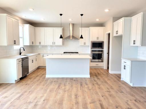 Kitchen is more spacious than the photos show. Enough room for the whole family or to entertain. Actual home will include our Signature kitchen appliance pkg inclusive of true built-in double wall ovens, range with microwave above - vented out.