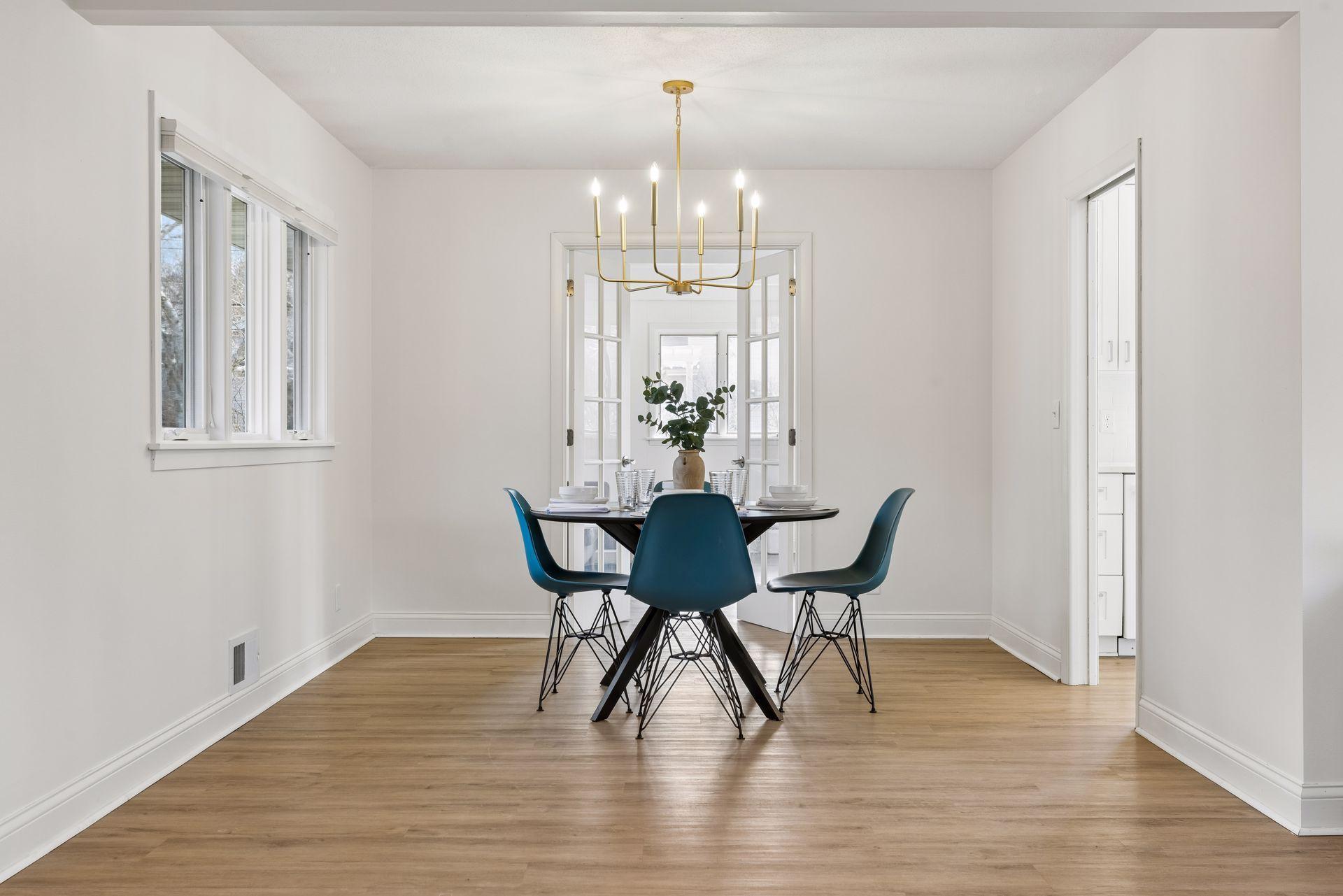 Dining room just off the kitchen, with updated lighting, opens to main floor den, family room, or technically a fourth bedroom.