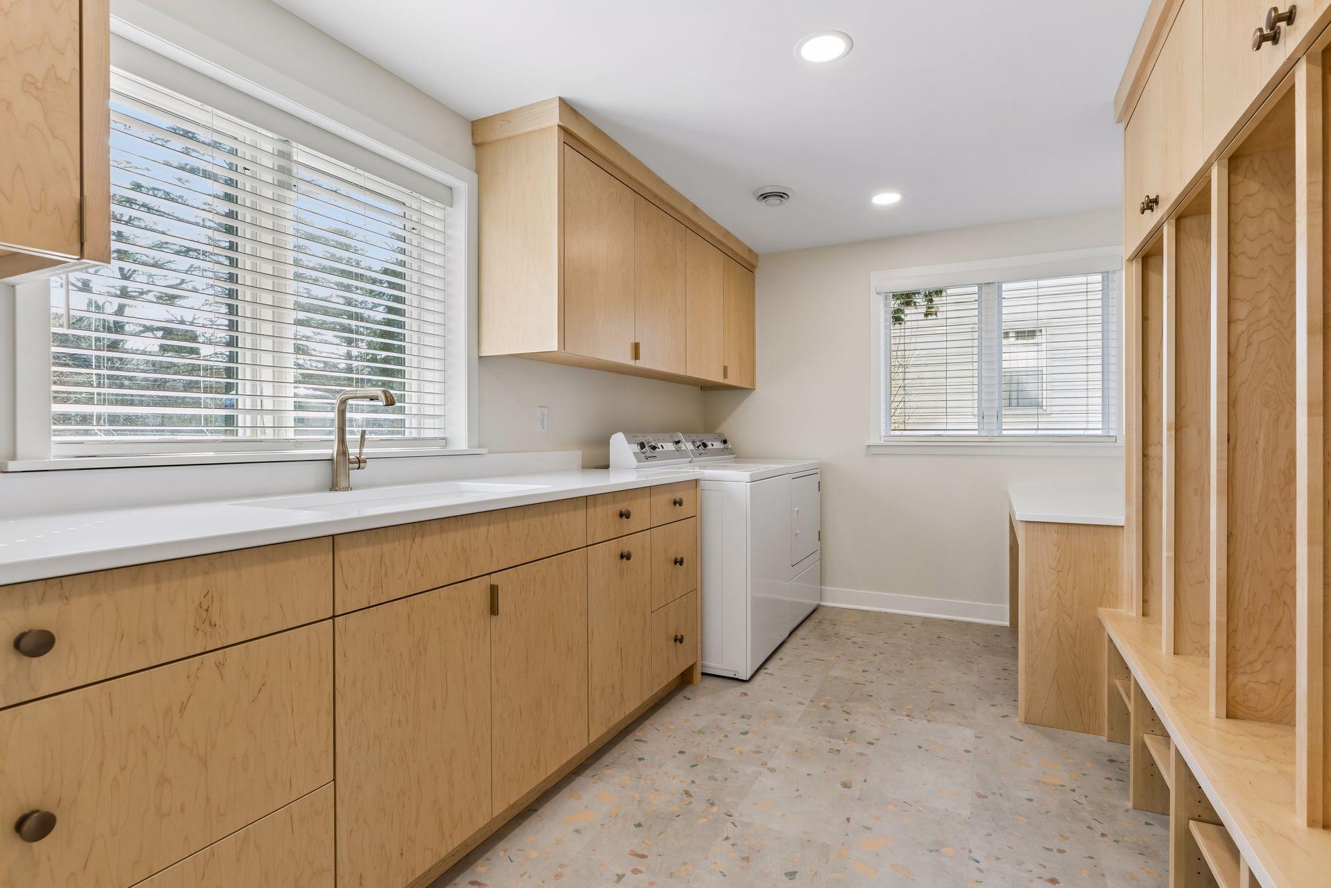 Quartz countertops, speed queen washer and electric dryer, solid maple cabinetry, lockers and coat rack, and built-ins with display space.