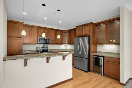 The bright, open kitchen features gorgeous cabinetry, granite countertops and stainless steel appliances